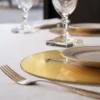 Sottopiatto rotondo Colomba su piedistallo in vetro grafite con sfondo in foglia oro