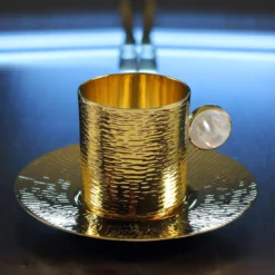 Tazza Demitasse placcata oro con piattino e bastoncino per mescolare